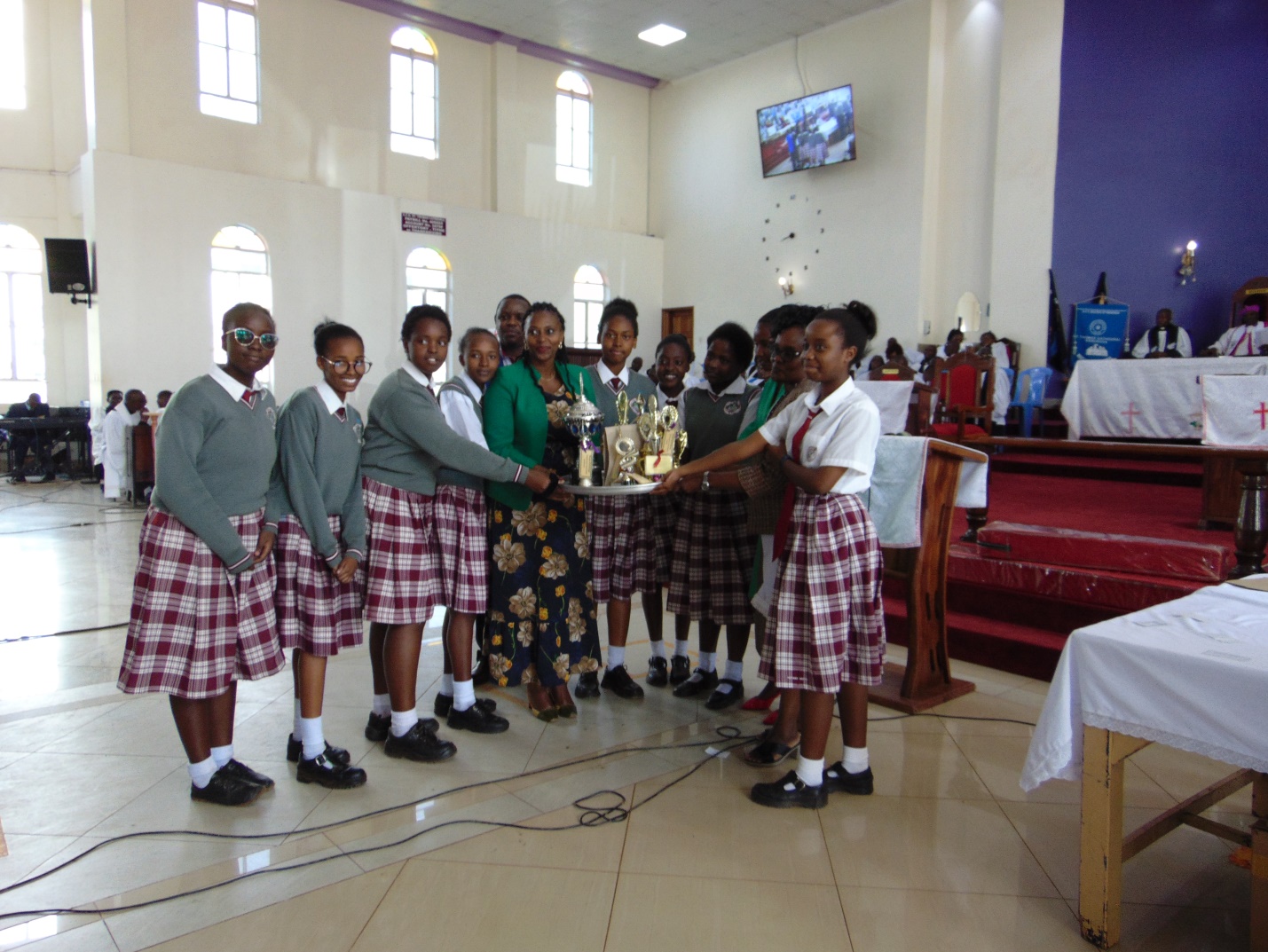 MADAM MARY MUTHONI MURIUKI (P.S. MINISTRY OF HEALTH) PRESENTING TROPHIES TO KABARE GIRLS HIGH SCHOOL DURING THE DIOCESAN EDUCATION DAY.